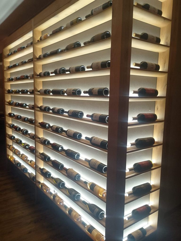 Weinregal mit LED Beleuchtung für die Gastronomie Weinregal mit mehreren Reihen von Flaschen, sanft beleuchtet.
